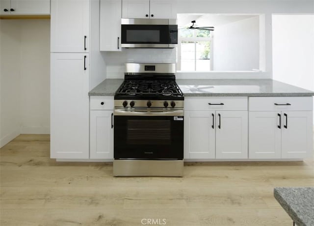 14163 Wimbleton Dr, Victorville, CA 92395 - kitchen with stainless steel appliances, light stone countertops, light wood-style floors, and white cabinets