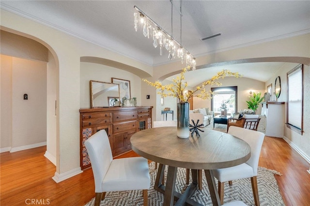 5855 Lemon Ave, Long Beach, CA 90805 - dining area with arched walkways, wood finished floors, and crown molding