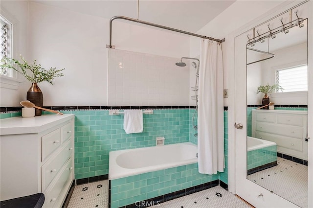 5855 Lemon Ave, Long Beach, CA 90805 - bathroom featuring tiled shower / bath combo, tile walls, tile patterned flooring, and a wainscoted wall
