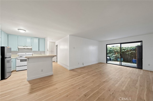 4647 Pico St Unit 101, San Diego, CA 92109 - kitchen featuring white range with electric cooktop, freestanding refrigerator, under cabinet range hood, light countertops, and blue cabinetry
