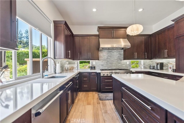 949 Moody Pl, Claremont, CA 91711 - kitchen with under cabinet range hood, healthy amount of natural light, light countertops, stainless steel dishwasher, and recessed lighting