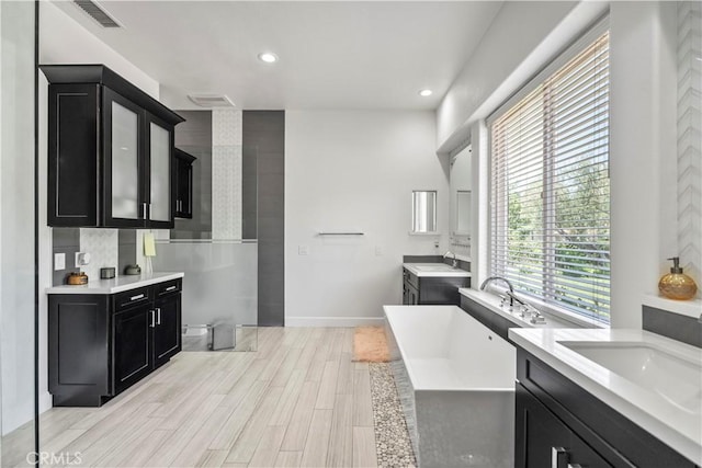 949 Moody Pl, Claremont, CA 91711 - full bathroom featuring a soaking tub, two vanities, wood finished floors, and recessed lighting