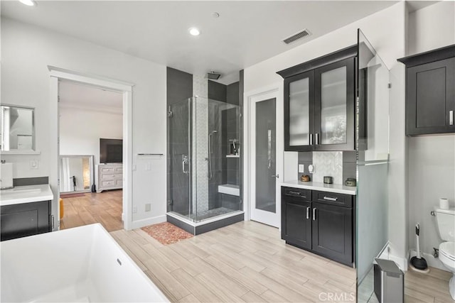 949 Moody Pl, Claremont, CA 91711 - full bath with a shower stall, wood finished floors, a freestanding bath, recessed lighting, and vanity