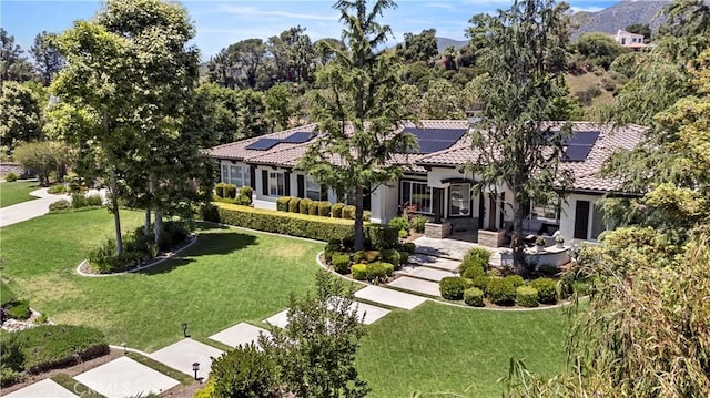 949 Moody Pl, Claremont, CA 91711 - mediterranean / spanish-style home featuring a front lawn, a tiled roof, roof mounted solar panels, and stucco siding