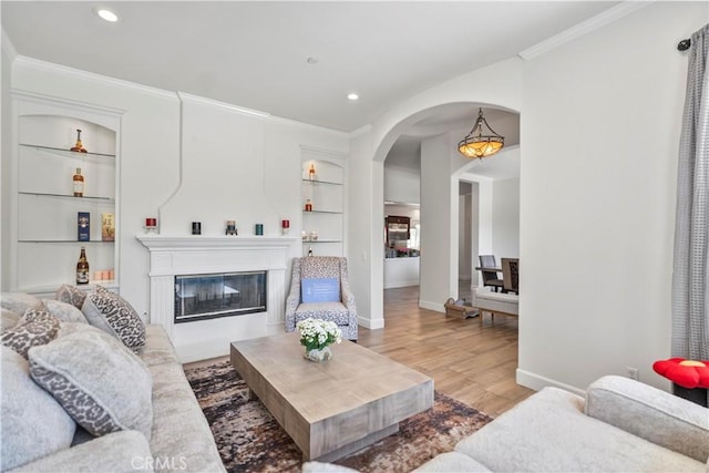 949 Moody Pl, Claremont, CA 91711 - living area featuring built in features, ornamental molding, light wood-style flooring, arched walkways, and recessed lighting