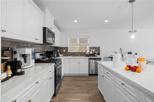 20225 Breeze Blooms Dr, Riverside, CA 92507 - kitchen featuring stainless steel appliances, backsplash, light countertops, white cabinets, and dark wood finished floors