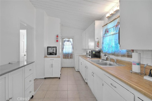 17109 E Orkney St, Azusa, CA 91702 - kitchen featuring stainless steel microwave, light tile patterned flooring, light countertops, white cabinets, and vaulted ceiling