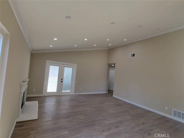 955 Mill Iron Way, San Jacinto, CA 92583 - unfurnished living room with crown molding, wood finished floors, recessed lighting, vaulted ceiling, and french doors