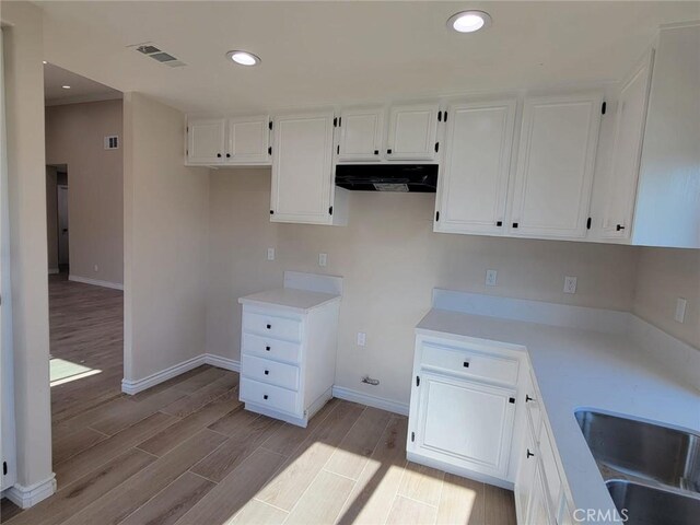955 Mill Iron Way, San Jacinto, CA 92583 - kitchen featuring extractor fan, light wood-style flooring, white cabinets, light countertops, and recessed lighting
