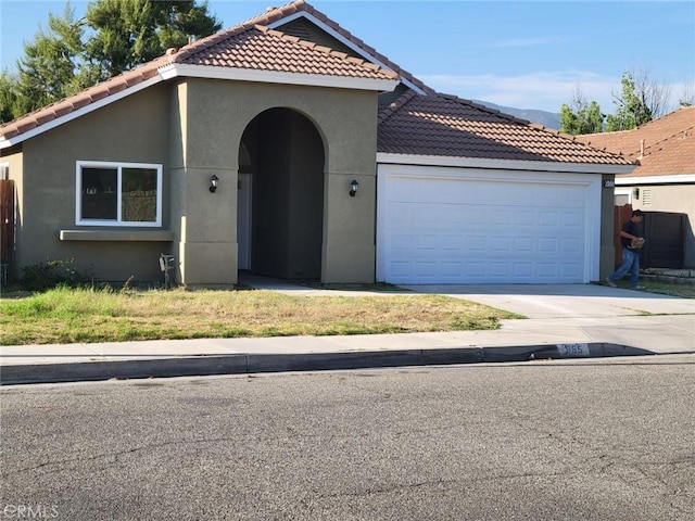 955 Mill Iron Way, San Jacinto, CA 92583 - mediterranean / spanish-style home featuring a tiled roof, stucco siding, a garage, and driveway