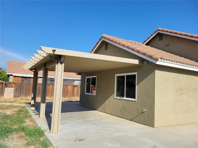 955 Mill Iron Way, San Jacinto, CA 92583 - back of house featuring stucco siding, a patio, and an attached carport