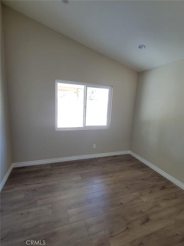 955 Mill Iron Way, San Jacinto, CA 92583 - unfurnished room with vaulted ceiling and wood finished floors