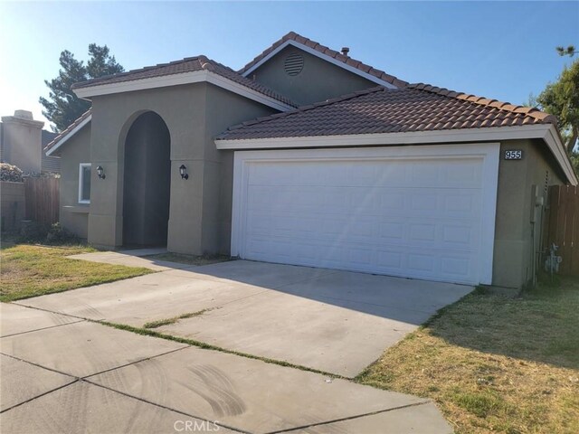 955 Mill Iron Way, San Jacinto, CA 92583 - view of front facade with driveway, an attached garage, stucco siding, and a tile roof