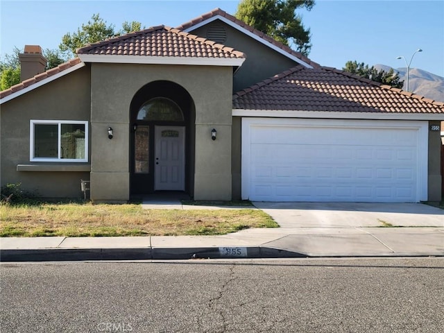 955 Mill Iron Way, San Jacinto, CA 92583 - mediterranean / spanish-style house with stucco siding, a tiled roof, an attached garage, and driveway