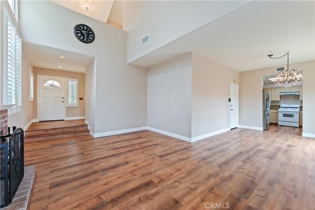 2547 Orange Ave Unit D, Costa Mesa, CA 92627 - unfurnished living room with a chandelier, wood finished floors, and a brick fireplace