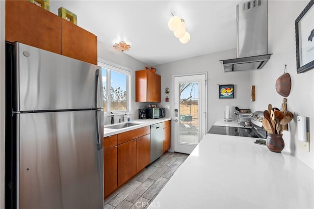 2654 Olympic Rd, Joshua Tree, CA 92252 - kitchen with stainless steel appliances, island exhaust hood, light countertops, wood finish floors, and brown cabinetry