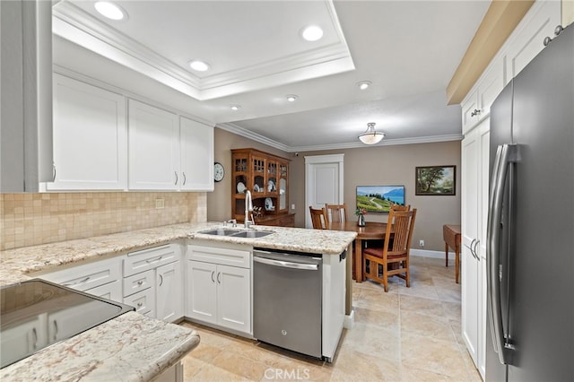 56 Ashbrook, Irvine, CA 92604 - kitchen with stainless steel appliances, a raised ceiling, crown molding, white cabinetry, and backsplash