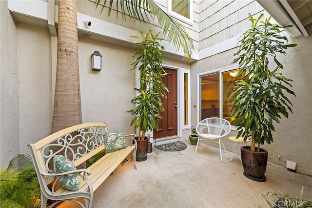 56 Ashbrook, Irvine, CA 92604 - property entrance with stucco siding, a patio area, and a surveillance system