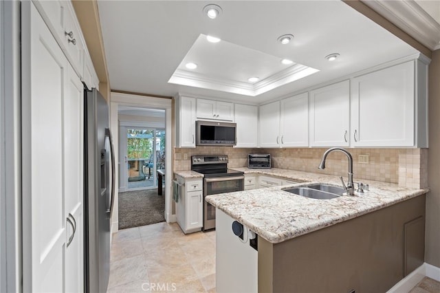 56 Ashbrook, Irvine, CA 92604 - kitchen featuring appliances with stainless steel finishes, a tray ceiling, a peninsula, decorative backsplash, and white cabinetry