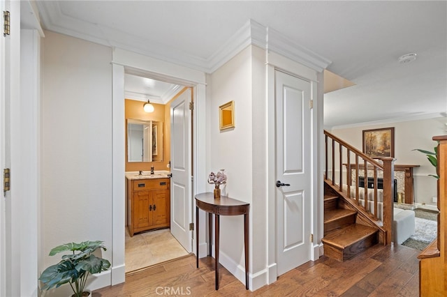 56 Ashbrook, Irvine, CA 92604 - hallway featuring light wood-type flooring, ornamental molding, and stairs
