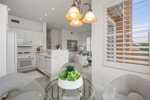1501 Reggio Aisle, Irvine, CA 92606 - kitchen featuring white appliances, a peninsula, open floor plan, white cabinets, and recessed lighting