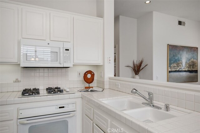 1501 Reggio Aisle, Irvine, CA 92606 - kitchen with white appliances, tile countertops, white cabinetry, decorative backsplash, and recessed lighting
