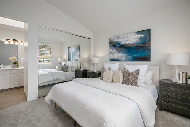 1501 Reggio Aisle, Irvine, CA 92606 - bedroom featuring a closet, light colored carpet, vaulted ceiling, and connected bathroom
