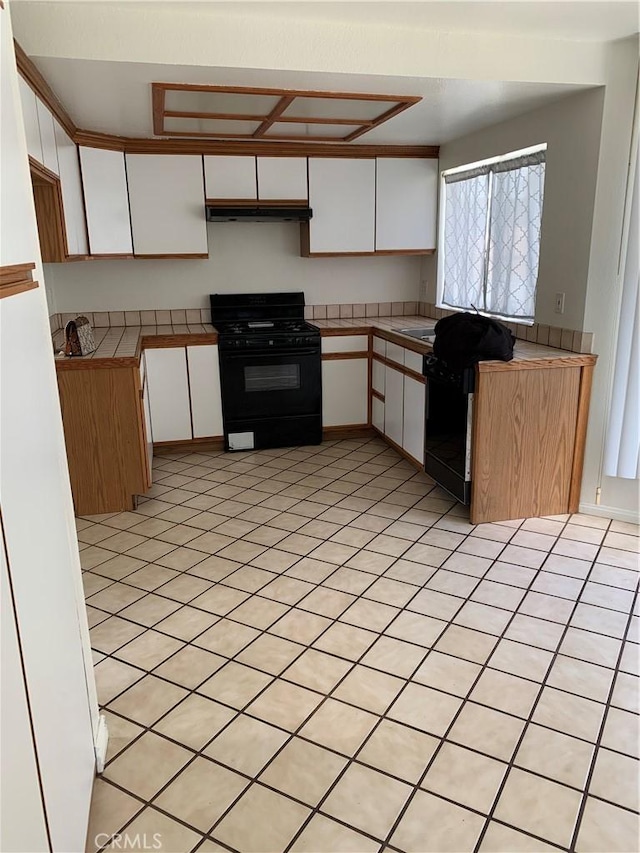 1509 W 146th St Unit 5, Gardena, CA 90247 - kitchen with black gas stove, under cabinet range hood, white cabinets, and dishwashing machine