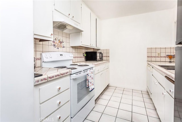 967 S Citron St Unit 3, Anaheim, CA 92805 - kitchen featuring white range with electric cooktop, under cabinet range hood, black microwave, tasteful backsplash, and white cabinetry