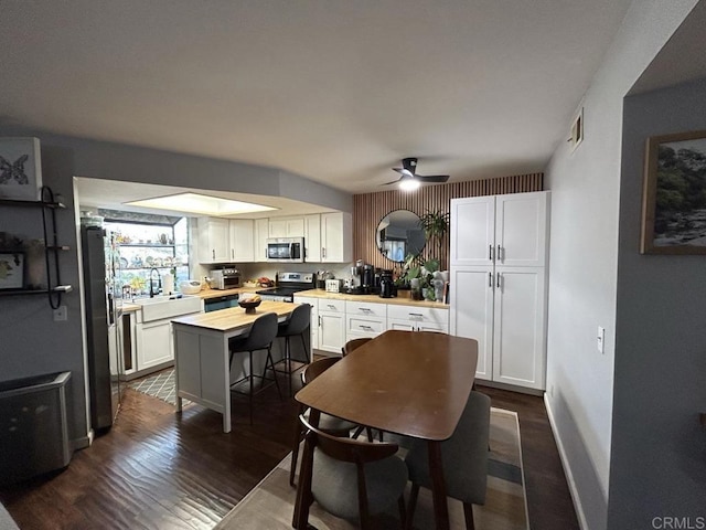 440 Citracado Pkwy Unit 30, Escondido, CA 92025 - kitchen with stainless steel appliances, white cabinets, dark wood-type flooring, a ceiling fan, and a center island