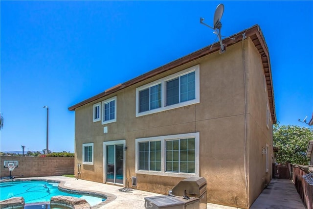 1802 Pummelo Dr, Redlands, CA 92374 - rear view of house featuring a patio area, a fenced backyard, stucco siding, and a pool with connected hot tub
