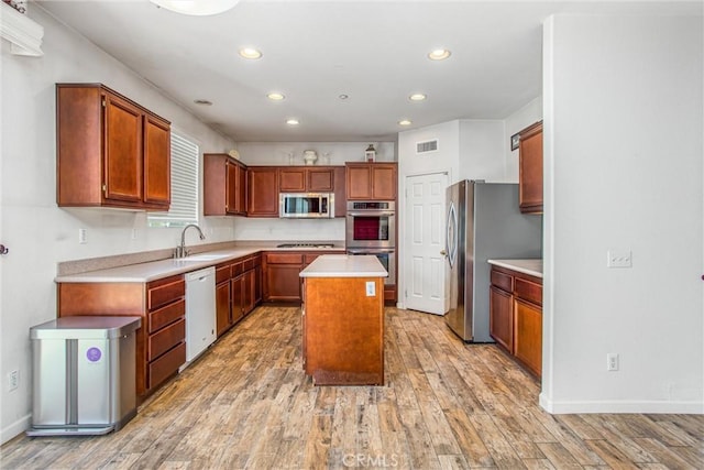 1802 Pummelo Dr, Redlands, CA 92374 - kitchen with appliances with stainless steel finishes, light wood-style floors, recessed lighting, a kitchen island, and light countertops
