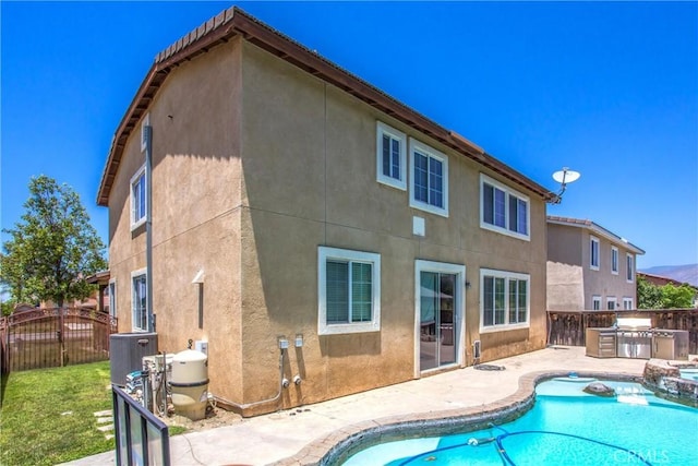 1802 Pummelo Dr, Redlands, CA 92374 - rear view of house with area for grilling, stucco siding, a patio, and a pool with connected hot tub