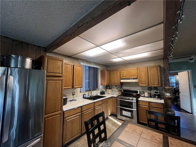 2200 Ximeno Ave, Long Beach, CA 90815 - kitchen featuring appliances with stainless steel finishes, light countertops, brown cabinetry, and light tile patterned flooring