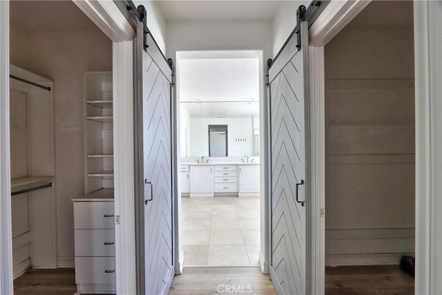 45118 Riverstone Ct, Temecula, CA 92592 - hallway with a barn door and light wood-type flooring