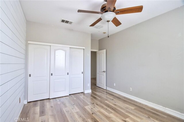 45118 Riverstone Ct, Temecula, CA 92592 - unfurnished bedroom with a closet, light wood-type flooring, wooden walls, and ceiling fan