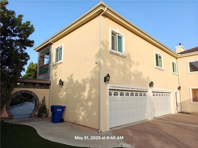 19910 Tennessee Trl, Walnut, CA 91789 - view of side of home featuring a garage, stucco siding, and driveway