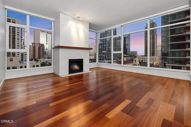 1205 Pacific Hwy Unit 1005, San Diego, CA 92101 - unfurnished living room featuring a view of city, wood finished floors, a fireplace with flush hearth, and a wall of windows