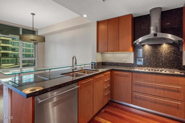 1205 Pacific Hwy Unit 1005, San Diego, CA 92101 - kitchen featuring stainless steel appliances, wall chimney range hood, dark stone counters, a peninsula, and dark wood-style floors