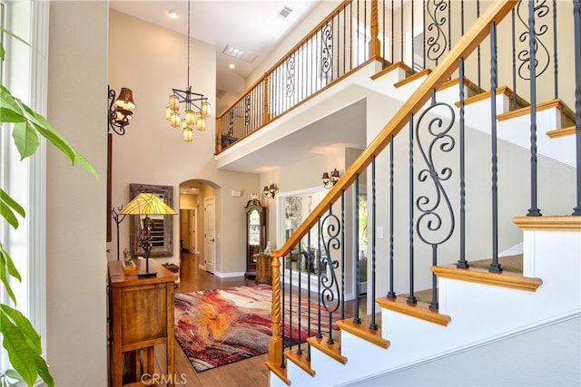 42768 El Calamar Rd, Temecula, CA 92590 - staircase featuring arched walkways, a high ceiling, wood finished floors, and a chandelier