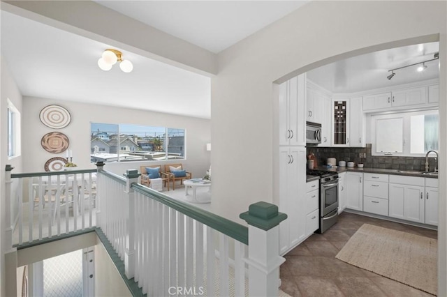 1715 Stanford Ave, Redondo Beach, CA 90278 - kitchen with stainless steel appliances, arched walkways, decorative backsplash, and white cabinets