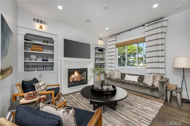 11385 Baskerville Rd, Rossmoor, CA 90720 - living area featuring wood finished floors, a glass covered fireplace, recessed lighting, and built in shelves