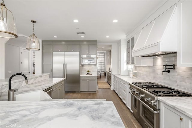 11385 Baskerville Rd, Rossmoor, CA 90720 - kitchen featuring high quality appliances, light stone countertops, decorative backsplash, decorative light fixtures, and gray cabinets