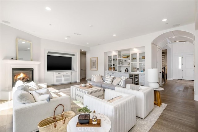 11385 Baskerville Rd, Rossmoor, CA 90720 - living area featuring arched walkways, wood finished floors, beverage cooler, a lit fireplace, and recessed lighting