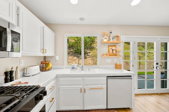 641 Hillhaven Dr, San Marcos, CA 92078 - kitchen featuring stainless steel microwave, dishwasher, white cabinets, light wood-type flooring, and tile countertops