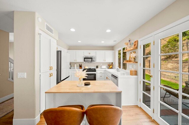 641 Hillhaven Dr, San Marcos, CA 92078 - kitchen featuring stainless steel appliances, butcher block countertops, light wood-style flooring, white cabinets, and recessed lighting
