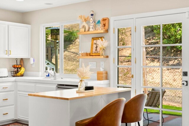641 Hillhaven Dr, San Marcos, CA 92078 - kitchen featuring white cabinetry, open shelves, and a breakfast bar
