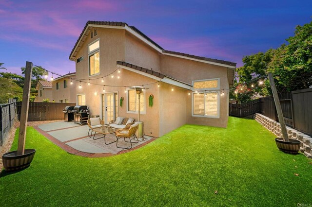 641 Hillhaven Dr, San Marcos, CA 92078 - back of property at dusk with stucco siding, a fenced backyard, and a patio area