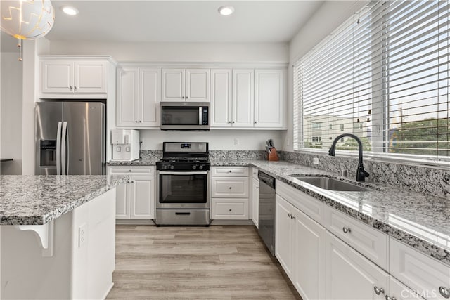 10648 Paramount Blvd, Downey, CA 90241 - kitchen with stainless steel appliances, recessed lighting, white cabinets, light wood-type flooring, and light stone counters