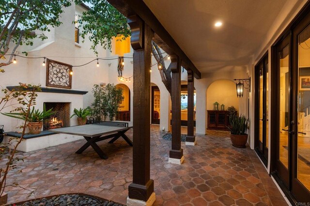 7691 Circulo Sequoia, Carlsbad, CA 92009 - view of patio / terrace with a lit fireplace and french doors